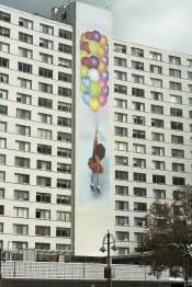 Thumbnail 37 of 38 - a mural of a girl holding balloons is shown on the side of an apartment building