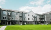 Thumbnail 15 of 52 - a rendering of an apartment complex with people walking on the lawn at The Commons at Rivertown, Grandville, 49418