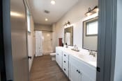 Thumbnail 42 of 52 - a bathroom with white cabinets and a sink and a toilet at The Commons at Rivertown, Grandville, 49418
