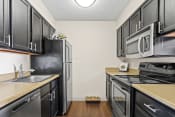 Thumbnail 2 of 29 - a kitchen with black cabinets and stainless steel appliances