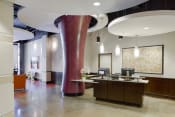 Thumbnail 16 of 26 - a lobby with a reception desk and a large red pillar