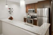 Thumbnail 3 of 26 - a kitchen with granite counter tops and stainless steel appliances