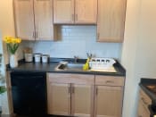Thumbnail 11 of 45 - Kitchen with wooden cabinets and a black dishwasher