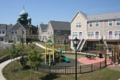 Thumbnail 7 of 23 - Apartment building exterior and playground area, Tremont Pointe Apartments