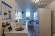 Thumbnail 43 of 54 - a laundry room with a row of washers and dryers  at Club at Emerald Waters, Hollywood, FL, 33021