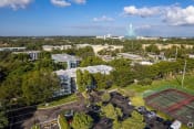 Thumbnail 41 of 54 - an aerial view of the campus with a tennis court in the foreground and a large building in  at Club at Emerald Waters, Florida