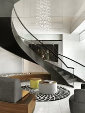 Thumbnail 5 of 19 - Lobby grand spiral staircase with curved sofa and round coffee table  at Clayton On The Park, Clayton, MO