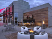 Thumbnail 19 of 19 - 24th floor sky deck at dusk with conversation seating, fire pit, bar and two televisions  at Clayton On The Park, Clayton, Missouri