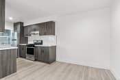 Thumbnail 15 of 23 - an empty kitchen with wood flooring and stainless steel appliances