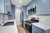 Thumbnail 22 of 43 - a kitchen with blue cabinets and stainless steel appliances