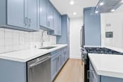 Thumbnail 1 of 43 - a kitchen with blue and white cabinets and stainless steel appliances