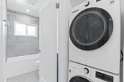 Thumbnail 7 of 43 - a white washer and dryer in a bathroom with a shower and a toilet