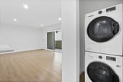Thumbnail 4 of 12 - a washer and dryer in a room with a wood floor and a white