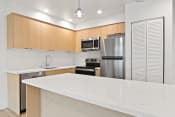 Thumbnail 43 of 57 - a kitchen with a white counter top and a stainless steel refrigerator