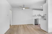 Thumbnail 3 of 23 - an empty kitchen with white cabinets and a ceiling fan