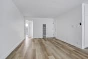 Thumbnail 10 of 48 - an empty living room with white walls and wooden floors