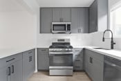 Thumbnail 15 of 43 - a kitchen with stainless steel appliances and gray cabinets
