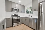 Thumbnail 24 of 43 - a kitchen with stainless steel appliances and gray cabinets