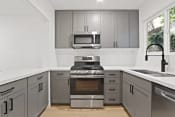 Thumbnail 25 of 43 - a modern kitchen with stainless steel appliances and gray cabinets