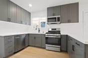 Thumbnail 34 of 43 - a modern kitchen with stainless steel appliances and gray cabinets