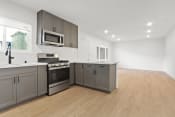 Thumbnail 35 of 43 - a renovated kitchen with gray cabinets and stainless steel appliances