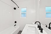 Thumbnail 41 of 43 - a white bathroom with a sink and a bath tub