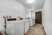 Thumbnail 16 of 17 - a laundry room with white appliances and white walls