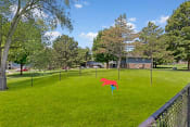 Thumbnail 5 of 38 - a large grassy area with a fence in the foreground and houses in the background