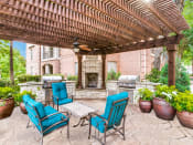 Thumbnail 16 of 20 - Luxury Apartments in North Dallas TX- Outdoor Patio With Fireplace, Two Grills, and Comfortable Blue Outdoor Chairs