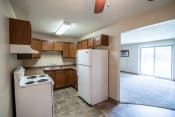 Thumbnail 7 of 16 - Bismarck, ND Eastbrook Apartments | a kitchen with white appliances and brown cabinets