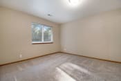 Thumbnail 7 of 10 - Omaha, NE Deerfield Apartments. An empty bedroom with a large window and beige walls