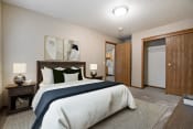Thumbnail 3 of 10 - Omaha, NE Deerfield Apartments. A bedroom with a bed and a door to a bathroom
