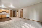 Thumbnail 6 of 10 - Omaha, NE Deerfield Apartments. A spacious living room with a kitchen in the background