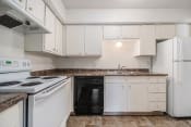 Thumbnail 7 of 9 - Omaha, NE Evergreen Terrace Apartments. A kitchen with white cabinets and black appliances