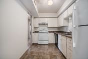 Thumbnail 6 of 9 - Omaha, NE Evergreen Terrace Apartments. A kitchen with white cabinets and white appliances