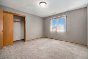 Thumbnail 11 of 24 - Omaha, NE Woodland Pines Apartment. A bedroom with a large window and a door to a closet