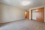 Thumbnail 22 of 24 - Omaha, NE Woodland Pines Apartments. A bedroom with a closet and a door to a bathroom