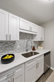 Thumbnail 23 of 64 - a white kitchen with a sink and white cabinets