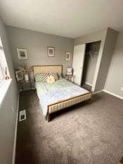 Thumbnail 20 of 50 - a bedroom with gray walls and a bed with a blue comforterat Centerpointe Apartments, Canandaigua, NY, 14424