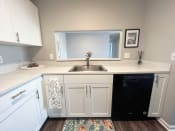 Thumbnail 2 of 50 - a small kitchen with white cabinets and a black dishwasherat Centerpointe Apartments, Canandaigua, NY