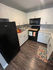 Thumbnail 4 of 50 - a kitchen with white cabinets and black appliancesat Centerpointe Apartments, Canandaigua