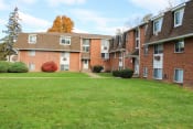 Thumbnail 72 of 79 - an apartment complex with a green lawn and a sidewalk at Willowbrooke Apartments, Brockport, New York