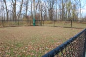 Thumbnail 51 of 79 - a dog park with a fence and a bench at Willowbrooke Apartments, Brockport, New York