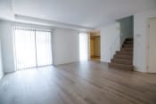 Thumbnail 12 of 36 - an empty living room with wood floors and a staircase