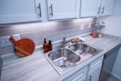 Thumbnail 6 of 36 - a stainless steel sink in a kitchen with white cabinets
