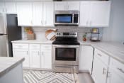 Thumbnail 5 of 36 - a white kitchen with a stove and a microwave