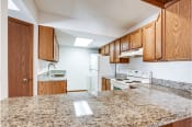 Thumbnail 26 of 36 - a kitchen with white appliances and granite counter tops