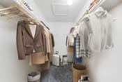 Thumbnail 48 of 58 - a walk in closet with clothes hanging on a rack and a toilet in the corner  at Vesper, Dallas, 75254