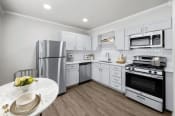 Thumbnail 4 of 55 - a kitchen with white cabinetry and stainless steel appliances  at Sunset Heights, San Antonio, Texas