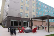 Thumbnail 9 of 54 - a patio with red chairs and tables in front of a building